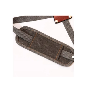 Detail of durable canvas apron strap with orange stitching and metal rivets