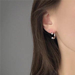 Close-up of chunky minimalist silver C-shaped hoop earrings on female model