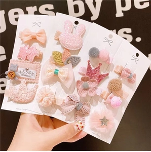 Cute pink fabric hair clips with crown and bow designs on display cards for girls