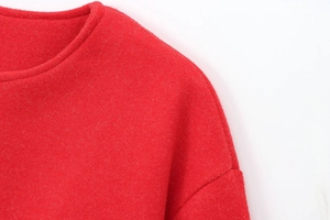 Close-up of the red plush fabric texture and stitching details on the bomber jacket