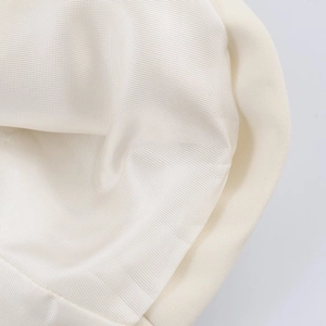 Macro shot of cream white twill fabric with silk-like sheen and soft texture detail