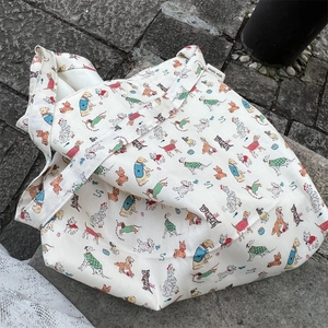 Detail of artistic dog print canvas tote bag with Simple Wish label on pavement