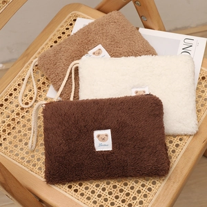 Three plush teddy bear makeup bags in brown, cream, and khaki with Lumu embroidery