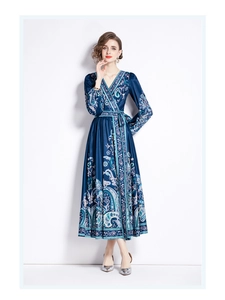 Detailed view of deep blue paisley print on a V-neck midi dress with waist tie and long sleeves