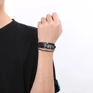Detail of multi-layer braided leather bracelet with silver anchor and helm charms for men