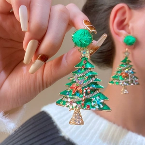 Detailed view of colorful rhinestone Christmas tree earrings with a green pom-pom top