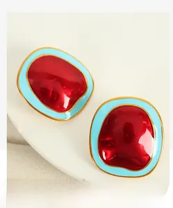 Detailed macro shot of vintage irregular red and blue contrast enamel gold earrings