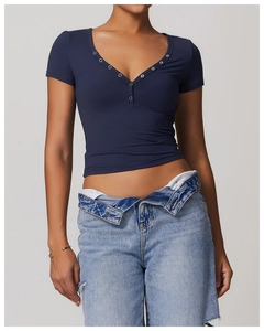 Close-up of deep blue breathable yoga tee featuring a V-neckline with silver metal buttons