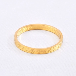 Detail showing continuous sunbeam pattern engraving on a 18k gold plated titanium ring
