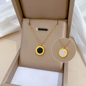 Detail view of Roman numeral necklaces with crystal insets in a luxury beige jewelry box