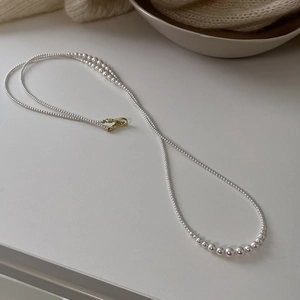 Elegant long white pearl necklace with golden clasp in a French vintage minimalist style