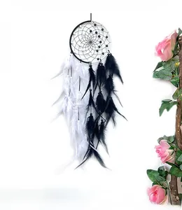 Close-up of yin yang dream catcher featuring black and white feathers and beads