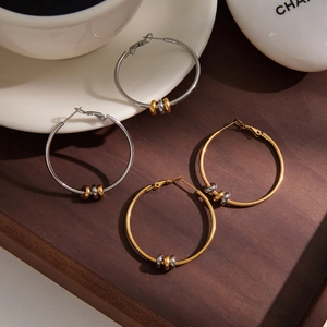 Details von Creolen aus Edelstahl in Gold und Silber mit beweglichen Perlen auf Tablett
