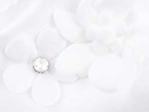 Detailed macro view of 3D white floral applique with central rhinestone on sweet style dress