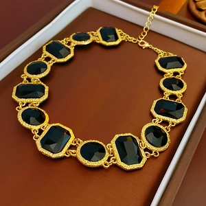Detailed view of vintage gold necklace with faceted black rectangular and oval gemstones