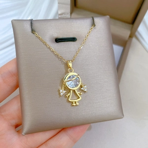 Detail view of a gold-plated girl pendant necklace with sparkling crystal embellishments