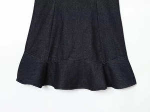 Close-up of dark denim dress hem featuring tiered ruffles and double-stitched craftsmanship