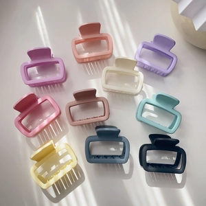 Flat lay of ten rectangular matte hair claws in assorted soft Morandi colors on white background