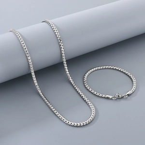 Close-up of silver stainless steel curb chain necklace and bracelet jewelry set