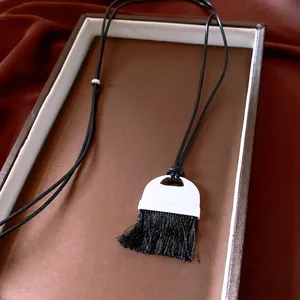 Minimalist vintage leather tassel pendant necklace on luxury velvet background display