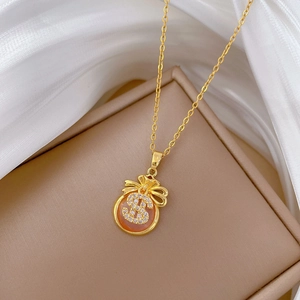 Macro detail of gold-tone fortune bag pendant with crystal-encrusted dollar sign