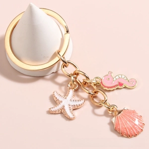 Detail of nautical keychain with pink enamel seahorse, shell, and starfish pendants