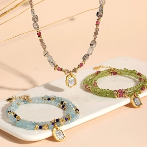 Exquisite peridot, aquamarine, and rutilated quartz beaded jewelry set on a ceramic tray