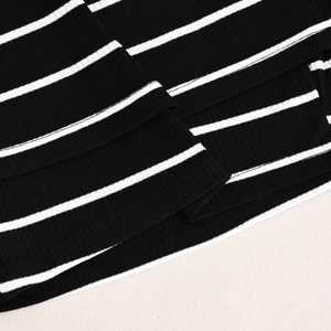 Detail of black and white striped knit fabric showing texture and layered hemline