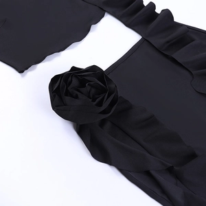 Close-up of black fabric with 3D floral rose applique and elegant ruffle texture detail