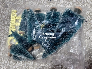 Overhead view of mini green frosted Christmas trees in a clear plastic bag packaging