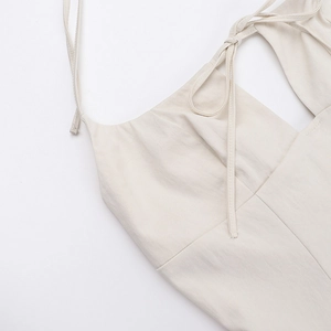 Détail d'une robe d'été beige avec de fines bretelles et un nœud décoratif élégant