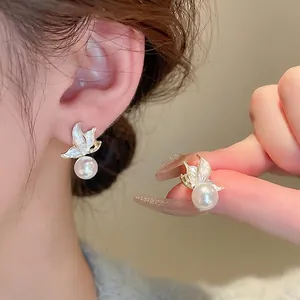 Elegant butterfly stud earrings with white enamel wings and high luster round pearls