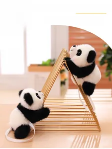 Close-up of cute panda plush toy with white shoulder strap on a gold metal frame