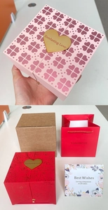 Detail view of pink and red double-door rose gift boxes with gift bags and greeting cards