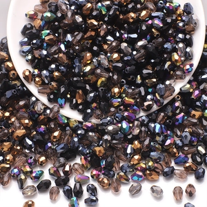Detailed view of faceted teardrop glass beads in black gold and iridescent colors