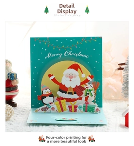 Detail view of a 3D pop-up Christmas card featuring Santa and penguins with Merry Christmas text