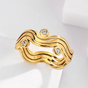 Macro shot of gold-plated stainless steel wavy ring with three inset clear crystals