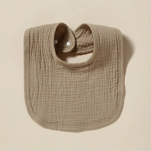 Soft brown multi-layer cotton gauze baby bib with snap buttons on beige background