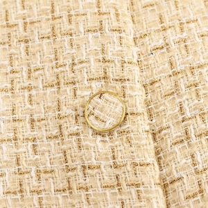 Beige textured tweed sleeveless vest with gold thread, sequins, and detailed button