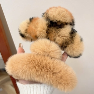 Close-up of plush rabbit fur claw clips in solid camel and leopard print patterns