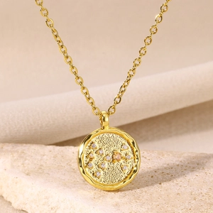 Macro shot of gold coin pendant necklace with zodiac constellation diamond inlay on stone