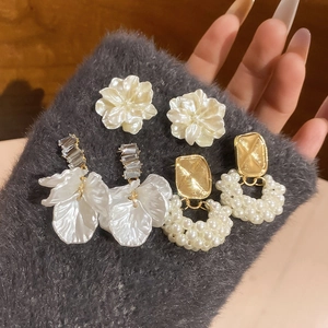 Dettaglio del set di orecchini con fiori e perle con strass mostrato in una vista a mano