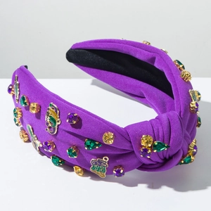Detail of purple Mardi Gras headband with colorful rhinestones and gold charm pendant