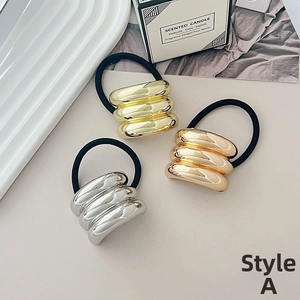 Close-up of gold, silver and rose gold metallic textured elastic hair ties set