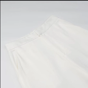 Détail de la couture à la taille et de la poche latérale de ce pantalon blanc chic