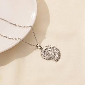 Macro shot of silver stainless steel nautilus shell pendant with spiral texture details