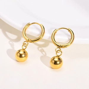Close-up of golden hoop earrings featuring a single round bead drop on white background