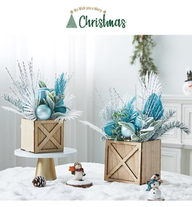 Mini lighted Christmas tree centerpieces in wooden pots with blue baubles and snow decor