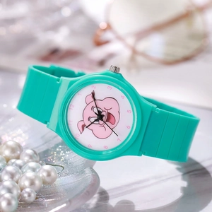 Macro detail of student quartz watch with green silicone strap and cartoon dial character
