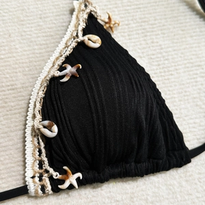 Close-up of black ribbed bikini top with crochet trim and starfish shell details